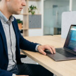 Homme en blazer analysant des graphiques et heatmaps sur un laptop pour un audit UX de site web et l'amélioration de la conversion.