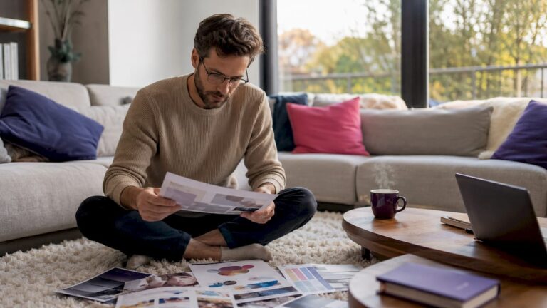 Une personne en train de comparer les brochures de différentes agences pour trouver la meilleure option.