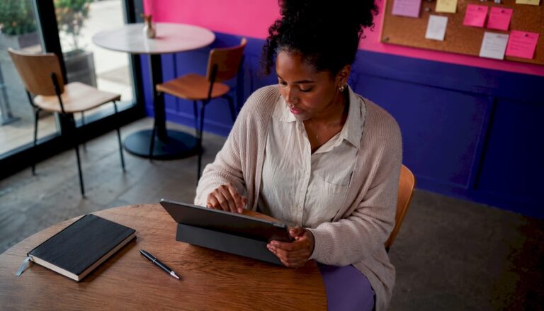 Une femme consulte les indicateurs clés de performance de la réussite d’un projet digital sur sa tablette.