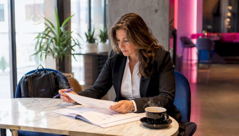 Une femme d’affaires examine attentivement des documents liés à la conformité numérique.