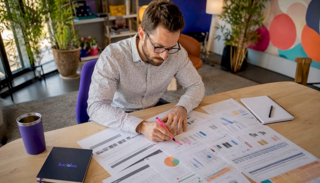 Installé à son bureau, un analyste passe en revue les rapports d’audit du CRM pour en tirer des conclusions pertinentes.