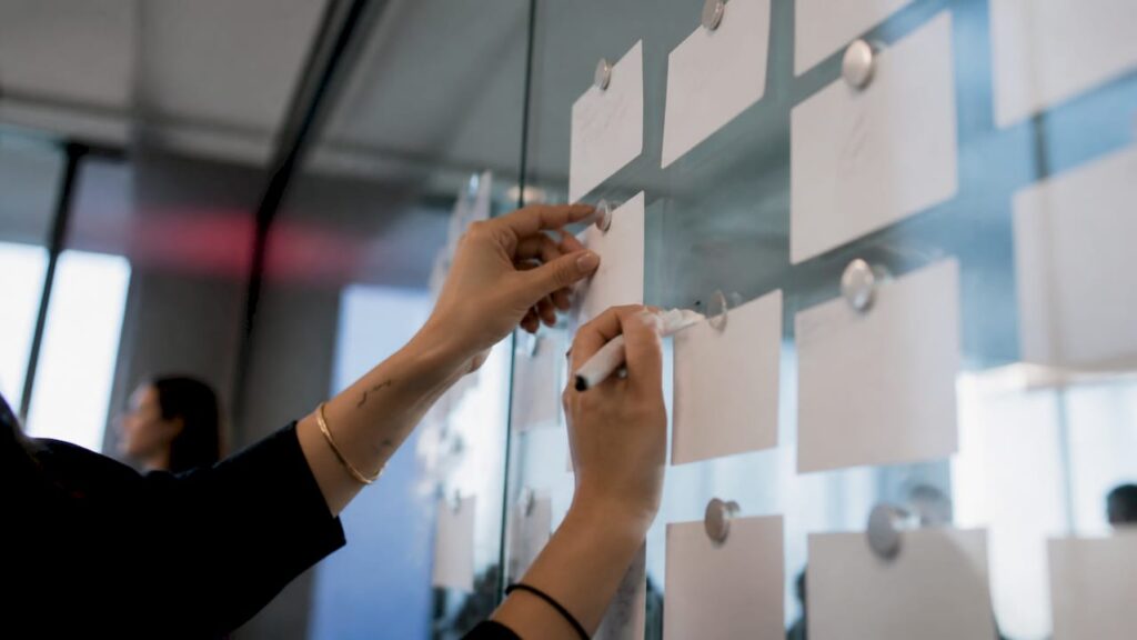 Des mains en train d’organiser des supports pour une campagne d’emailing