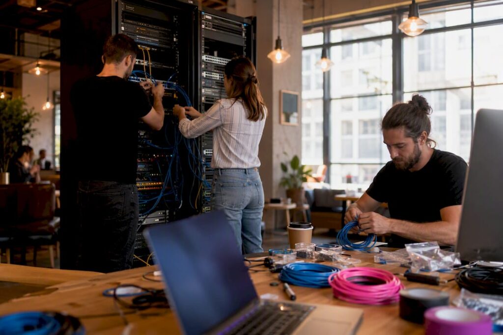 Des techniciens s'affairent à connecter des câbles réseau pour mettre en place une solution CRM.