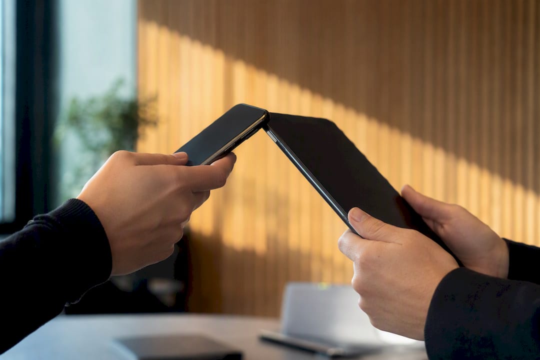10 vérifications CNIL pour optimiser votre bandeau cookies en France 2 Mains tenant un smartphone et une tablette synchronisant les consentements