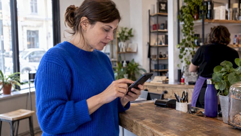 Femme dirigeante en train d'essayer un agent conversationnel sur smartphone